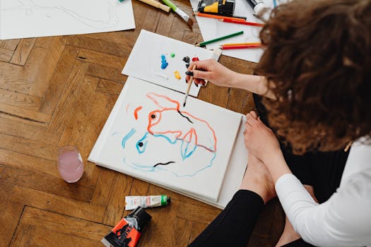 Artist painting abstract face on canvas with vibrant colors.